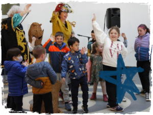 The Armagh Rhymers surrounded by children at Museum of Liverpool.