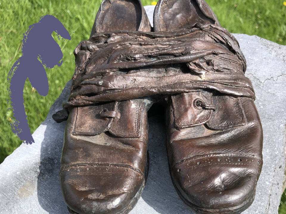 Close up photograph of a pair of bronze shoes, cast from an original nineteenth century children's pair.
